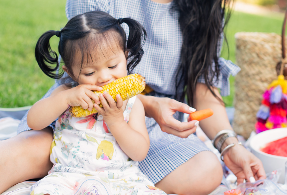 baby Kennedy enjoying elotes on family picnic, summer bucket list