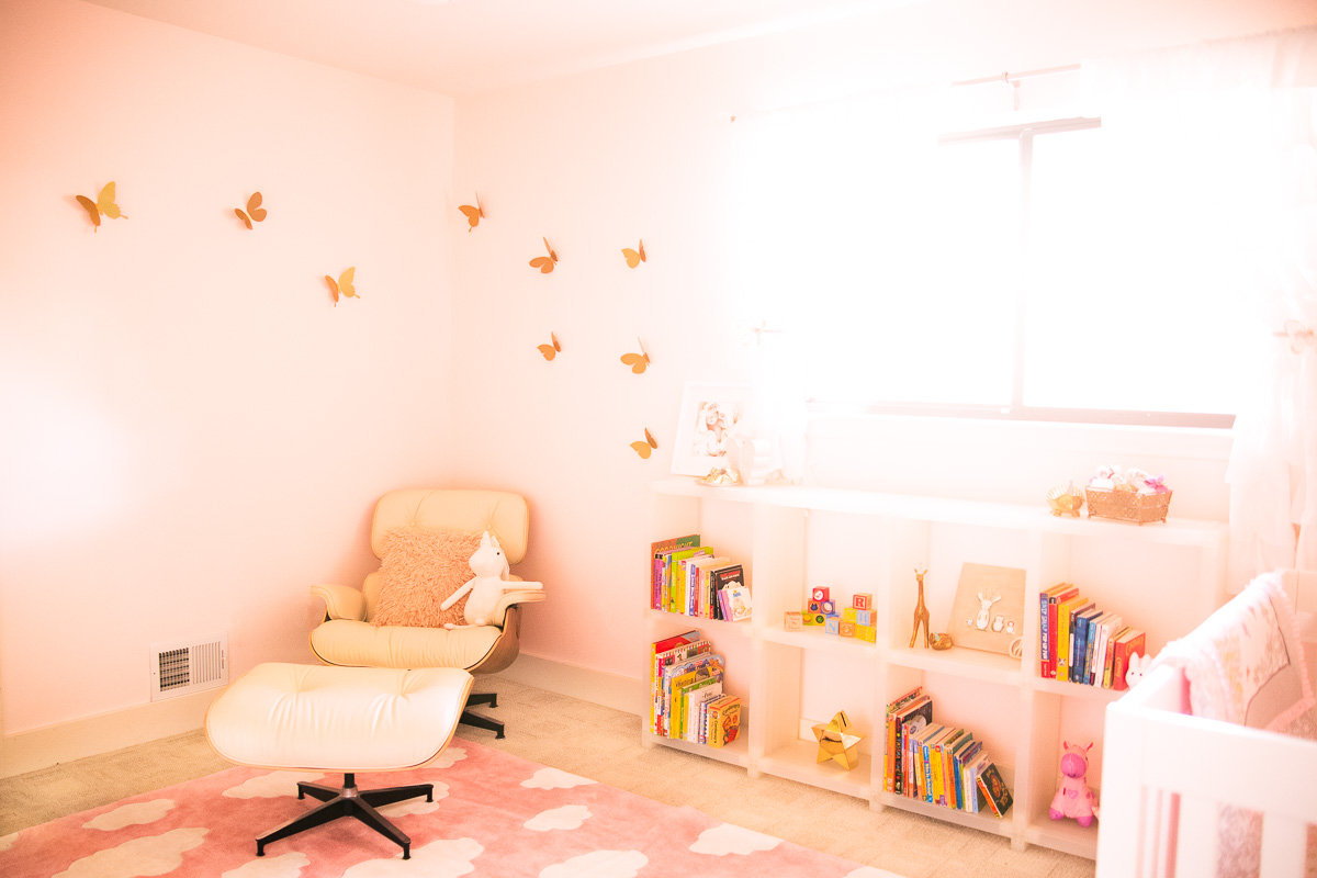 toddler girl unicorn butterfly nursery, pink cloud rug, cubitec shelf decor, eames lounge chair ottoman