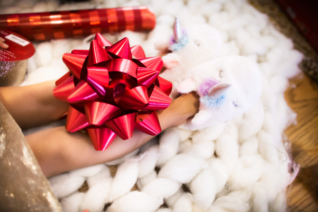 toddler girls wrapping gifts, carters unicorn fuzzy slippers | JCPenney | Husband | Father-in-Law | Boys | Girls | Gift Guide: Unique Gift Ideas For The Family featured by top Dallas life and style blog Cute & Little