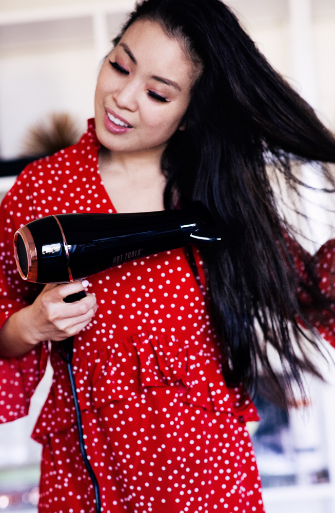 Valentine's Hairstyle featured by top US beauty blog Cute & Little; Image of woman in a red blouse doing her hair.