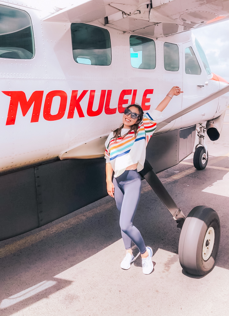 Visiting Molokai featured by top US travel blog Cute & Little; Image of a woman wearing striped sweater, Aerie Play Me Real Leggings, Nike Epic React Sneakers and Aerie Good Day Sunglasses.