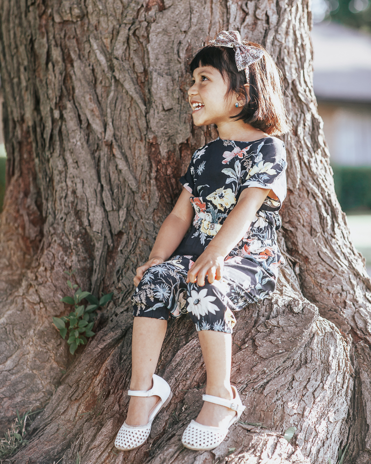 Becoming A Mom featured by top US life and style blog Cute & Little; Image of a woman wearing LOFT floral jumpsuit, ASOS shoes and Amazon Gucci dupe bag and her daughter wearing loft littles floral bouquet jumpsuit.
