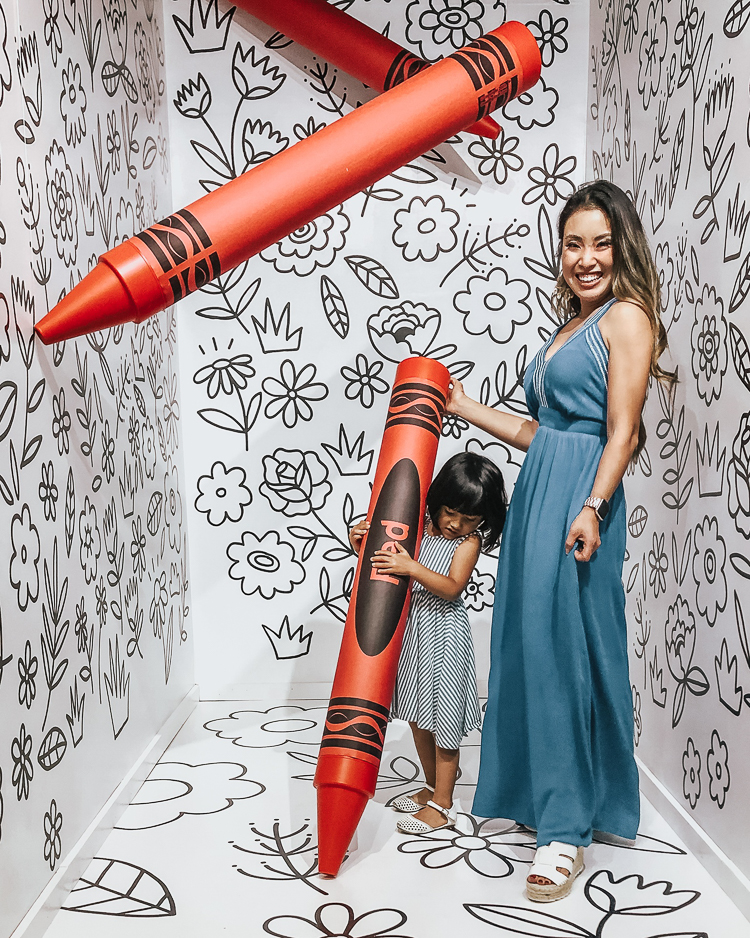 cute & little | popular dallas fashion mom blog | museum of memories instagram popup immersive art exhibit | Take a Selfie of Your Childhood: Museum of Memories by popular Dallas blog Cute and Little: image of woman and young girl holding a life size red crayon in an interactive coloring room.  The woman is wearing a Gibson x Hi Sugarplum! Santorini Maxi, Marc Fisher 'Robbyn' Espadrilles, and Panacea Shell Rope Hoops and a little girl wearing an Alice & Ames Tank Ballet Dress and Nine West Kids 'Vivien' Mary Janes.   