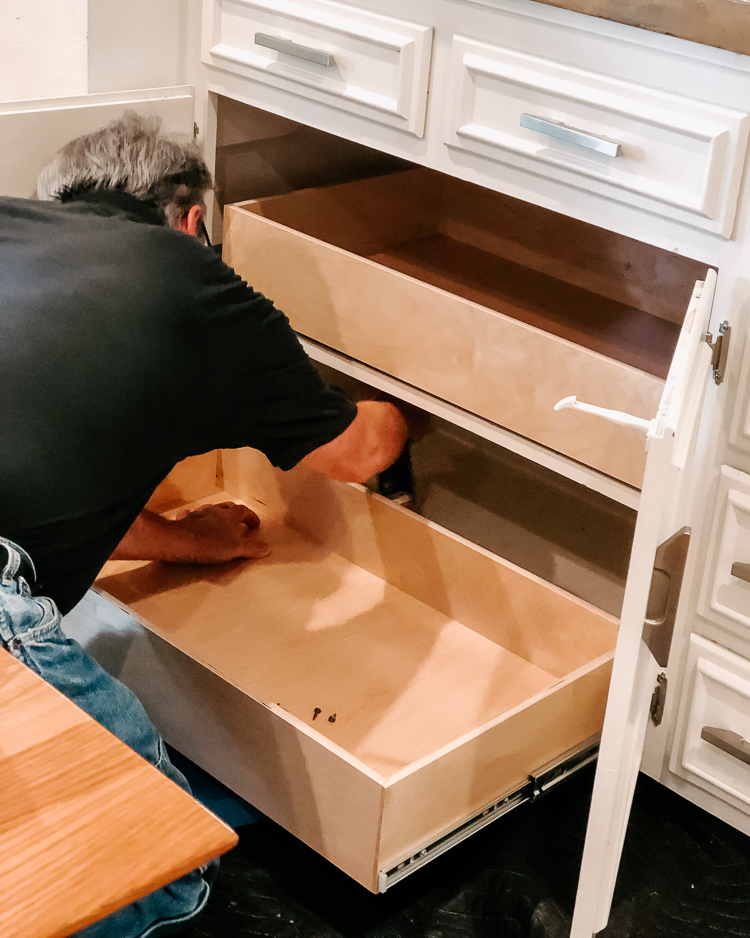 cute & little | popular dallas home blogger | shelfgenie home improvement organization review | quick and easy tips to organize your kitchen | Quick Kitchen Organization Tips with ShelfGenie by popular Dallas lifestyle blog, Cute and Little: image of man installing shelfgenie glide-out drawers in a kitchen.