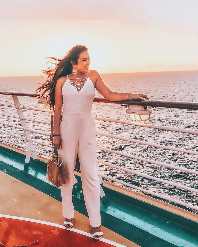 First Time Cruise Tips featured by top US travel blog Cute & Little; Image of a woman wearing express white lace-up lace jumpsuit and Baublebar earrings.