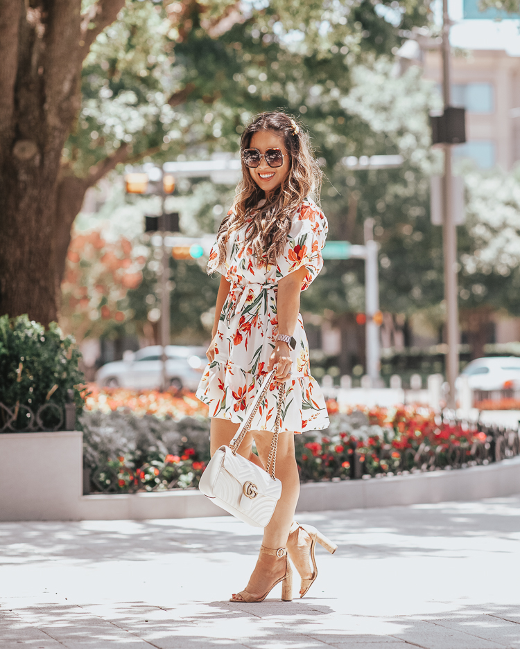 cute & little | dallas fashion blog | top 10 dallas brunch restaurants family kid friendly | shein white floral ruffle wrap dress | summer fall wedding guest outfit | Best Brunch In Dallas: 10 Restaurants To Try by popular Dallas blog, Cute and Little: image of a woman outside and wearing a Shein Floral Print Ruffle Hem Belted Dress, Etsy Rhinestone “GUCCI” Inspired Hair Clip, Etsy Bling Babes Code Gold Rhinestone Xoxo hair clip, Gucci GG Marmont small matelassé shoulder bag, and Gucci GG 0106 S- GG0106S Sunglasses 56mm.