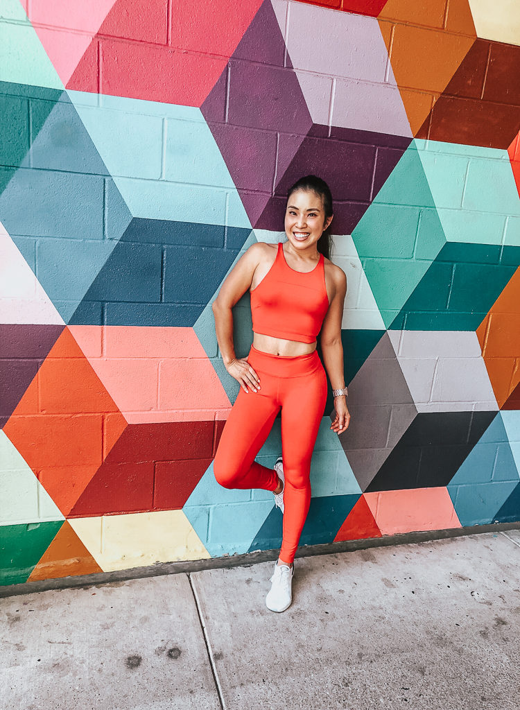 cute & little | popular dallas fashion blog | dallas mural guide | instagram walls | color blocks wall | west village uptown | Dallas Mural Guide: Top 10 Instagram Walls by popular Dallas blog, Cute and Little: image of a woman standing in front of a geometric shapes mural and wearing a Outdoor Voices TechSweat Crop Top, Outdoor Voices TechSweat 7/8 Leggings, and Dick's Nike Men's Epic React Flyknit 2 Running Shoes.