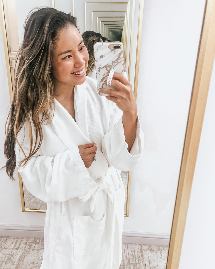 cute & little | dallas beauty lifestyle mom blog | self care spa day ritual | spa at crescent court facial cryotherapy review | Self Care Spa Day: Facial + Cryo At The Crescent Court in Dallas by popular Dallas beauty blog, Cute and Little: image of a woman taking a selfie in a full length mirror and wearing a white robe.