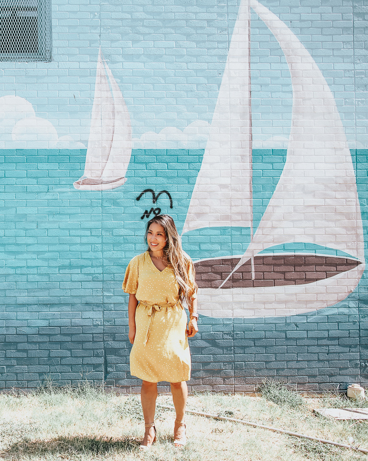 cute & little | popular dallas fashion blog | dallas mural guide | instagram walls | nautical ships wall | deep ellum | Dallas Mural Guide: Top 10 Instagram Walls by popular Dallas blog, Cute and Little: image of a woman standing in front of a blue sailboats mural and wearing a Target A New Day Tie Waist Dress and wearing Sam Edelman sandals.