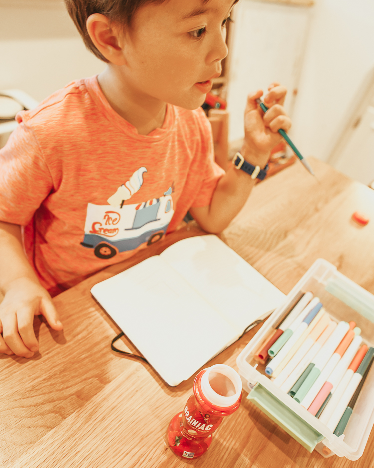 cute & little | popular dallas mom parenting blog | kids healthy quick easy breakfast ideas school | brainiac yogurt review | 5 Easy Breakfast Ideas for Kids That Maximize Brain Power by popular Dallas lifestyle blog, Cute and Little: image of a boy writing in a notebook.