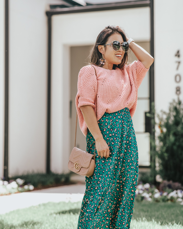 cute & little | popular dallas fashion blog | green animal print leopard midi skirt, pink ribbed chenille sweater, pink bow pumps | summer fall work office outfit | A Green Take On The Animal Print Midi Skirt by popular Dallas petite fashion blog, Cute and Little: image of a woman standing outside and wearing a Forever 21 Ribbed Chenille-Knit Sweater, Nordstrom Pamela Print Bias Cut Midi Skirt, Amazon SCHUTZ Women's Blasiana Pump, Nordstrom Baublebar Orchid Drop Earrings, Amazon Beatfull Bee Shoulder Bag for Women, Target Fitbit Versa Lite Smartwatch, and Gucci 63mm Open Temple Sunglasses. 