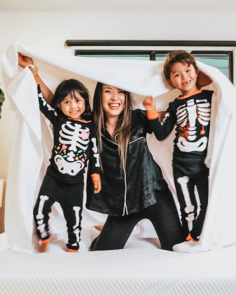 cute & little | dallas family fashion blog | family 4 group halloween costume idea | halloween skeleton matching pajamas | Last Minute Halloween Costumes for Families by popular Dallas petite life an style blog, Cute and Little: image of a mom and her two kids wearing Amazon carters skeleton pajamas, Target Stars Above Women's Beautifully Soft Crop Notch Collar Pajama Set.