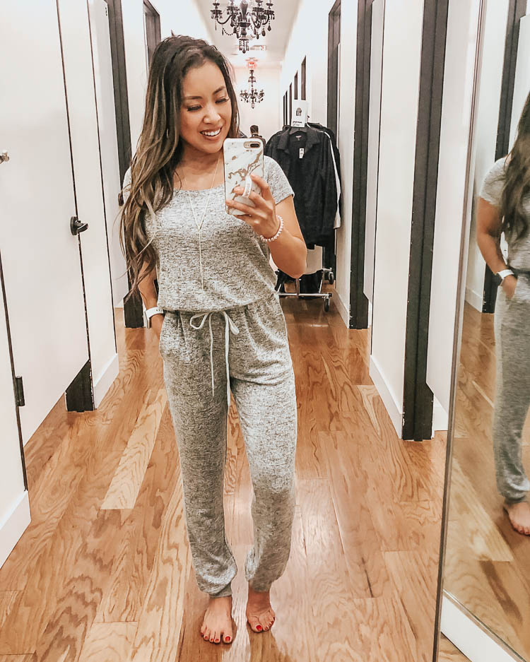 cute & little | dallas petite fashion blog | express fall september october try-on | express grey off-shoulder lounge jumpsuit | Express Fall Try-On October 2019 by popular Dallas petite fashion blog, Cute and Little: image of a woman standing in a dressing room and wearing an Express Heathered Off The Shoulder Lounge Drawstring Jumpsuit, ShopBop Gorjana Chloe Adjustable Necklace and Nordstrom Dolce Vita 'Noor' Cheetah Wedges.