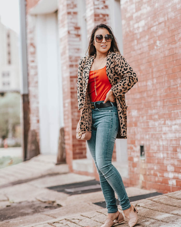 cute & little | dallas petite fashion blog | j.crew leopard sophie blazer, express rust orange bodysuit, express denim perfect jeans | fall outfit | Welcoming Fall In A Statement Leopard Blazer by popular Dallas petite fashion blog, Cute and Little: image of a woman walking outside and wearing a J. Crew Sophie open-front sweater-blazer in leopard, Express bag notification image ITEM ADDED TO YOUR BAG VIEW BAG High Waisted Denim Perfect Leggings, Gucci Thin Leather GG-Buckle Belt, Nordstrom Rack Vince Darlington Flat, and Gucci GG 0106 S- GG0106S Sunglasses 56mm.