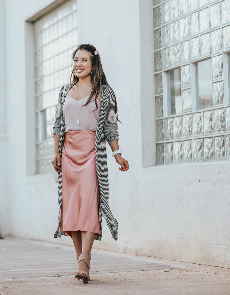 Silk slip skirt midi style for Fall by top US petite fashion blog, cute & little: image of a woman wearing a JCrew silk slip midi skirt, LOFT striped cardigan, Express Cami, Splendid Jayla shoes.| cute & little | dallas petite fashion blog | loft striped long duster cardigan, blush pink silk slip midi skirt | work office business casual outfit
