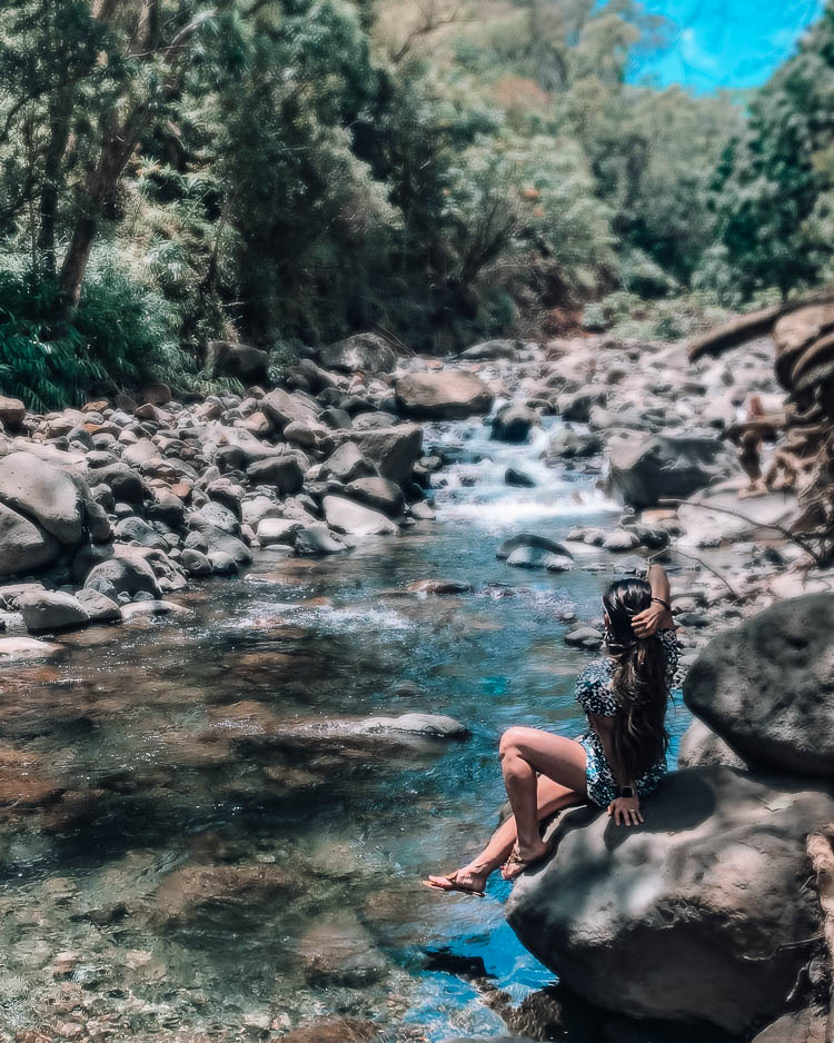 cute & little | dallas travel blog | maui hawaii vacation travel guide | iao valley hiking river | Maui Travel Tips: Off The Beaten Path by popular Dallas travel blog, Cute and Little: image of a woman hiking Iao valley and wearing a Loft LOFT BEACH FLORAL TIE WAIST ROMPER and Nordstrom Tory Burch Miller Flip Flop.