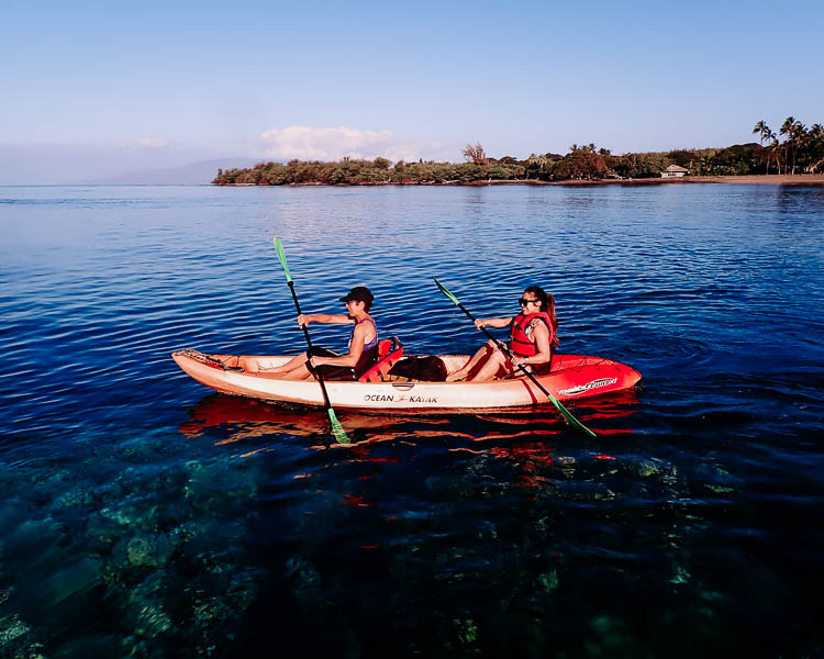 cute & little | dallas travel blog | maui hawaii vacation travel guide | kayaking Maui Travel Tips: Off The Beaten Path by popular Dallas travel blog, Cute and Little: image of a woman kayaking in the ocean with Hawaiian paddle sports. 