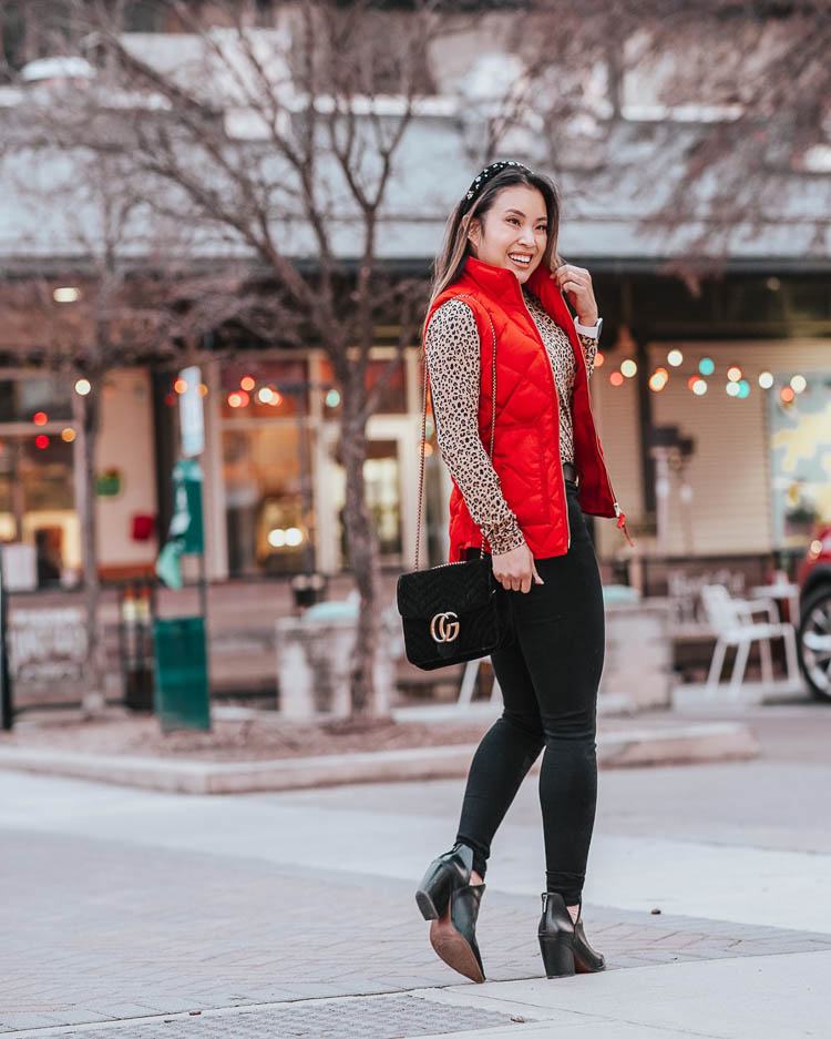 cute & little | dallas petite fashion blog | j.crew leopard turtleneck, red puffer quilted vest, black jeans | winter outfit | The Chic Headbands Trend by popular Dallas petite fashion blog, Cute and Little: image of a woman wearing a Loft EMBELLISHED HEADBAND, J. Crew Tissue turtleneck in leopard, J. Crew Excursion vest in recycled poly with PrimaLoft® fill, Gucci Leather belt with Double G buckle, American Eagle AE 360 NE(X)T LEVEL SUPER HIGH-WAISTED JEGGING, Fit Bit Versa Watch, and Nordstrom Vince Camuto Gigietta Bootie. 