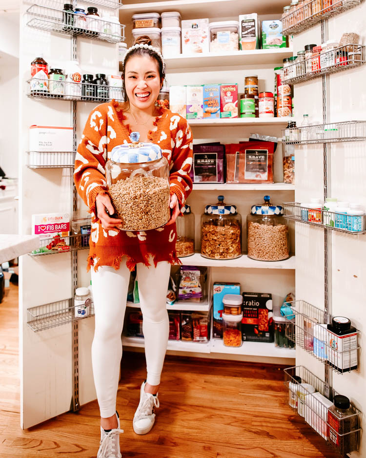 cute & little | dallas lifestyle blog | small pantry organization ideas tips | 5 Easy Tips for Small Pantry Organization by popular Dallas lifestyle blog, Cute and Little: image of a woman standing in front of her organized small pantry and wearing a Amaryllis Feline Festive Distressed Sweater, Lululemon Train Times Pant 25", Amazon willbond 4 Pieces Pearls Headbands White Faux Pearl Rhinestones, and Goodnight Macaroon 'VANESSA' SEQUINNED STAR DISTRESSED SNEAKERS. 