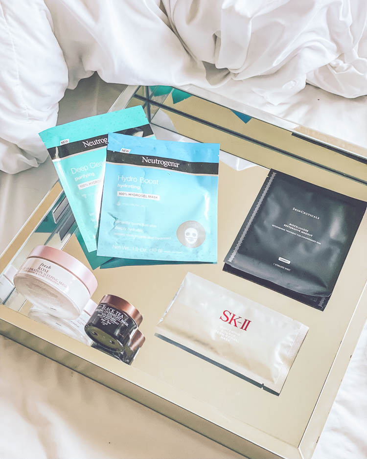 cute & little blog | favorite sleeping masks for glowing skin | Beauty Sleep Products by popular Dallas beauty blog, Cute and Little: image of a mirror tray with Neutrogena Hydro Boost Sheet Mask, Skinceuticals Biocellulose Restorative Masque, SK-II Whitening Revival Mask, Fresh Rose Deep Hydration Sleeping Mask, and Fresh Firming Overnight Mask on it.