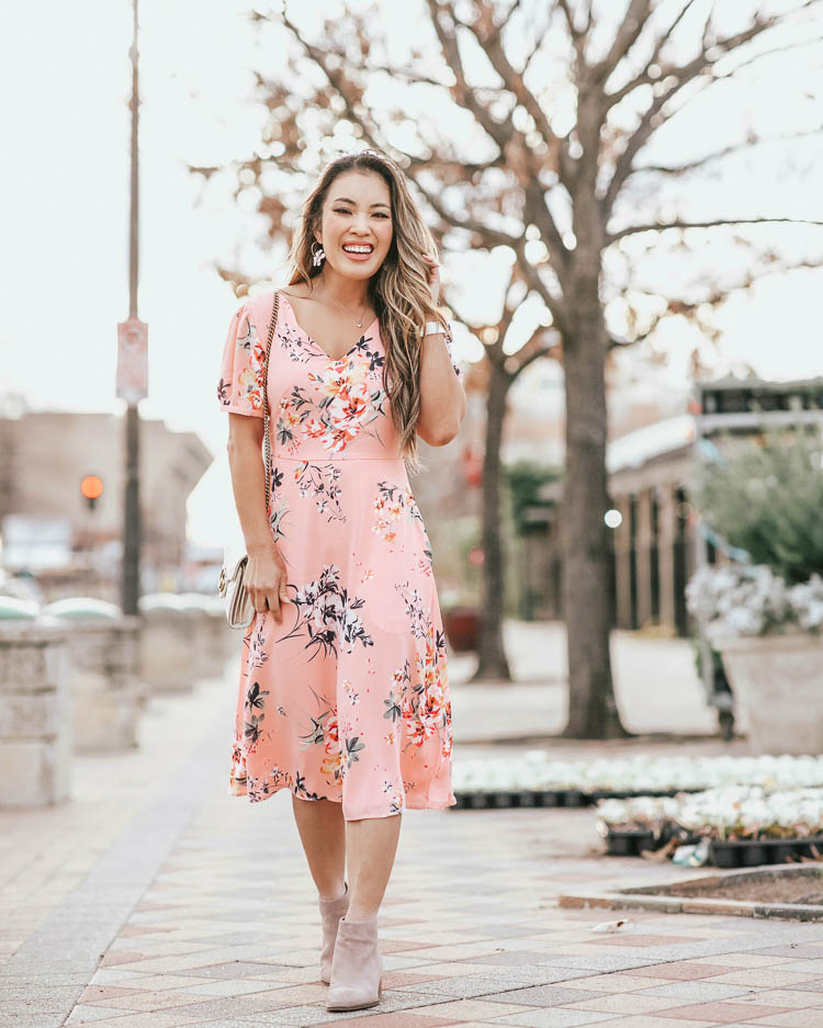 cute & little blog | dallas petite fashion | loft pink floral midi dress | spring outfit | Loft Sale by popular Dallas petite fashion blog, Cute and Little: image of a woman walking down a city street and wearing a Loft FLORAL SMOCKED BACK MIDI DRESS, Loft SEYCHELLES SUEDE FLOODPLAIN BOOTIES, Neiman Marcus GG Marmont Chevron Quilted Leather Flap Wallet on a Chain, Amazon Navachi 18k Gold Plated White Enamel Flower Crystal Az2461e Hoop Earrings, and Amazon WILLBOND pearl headband.