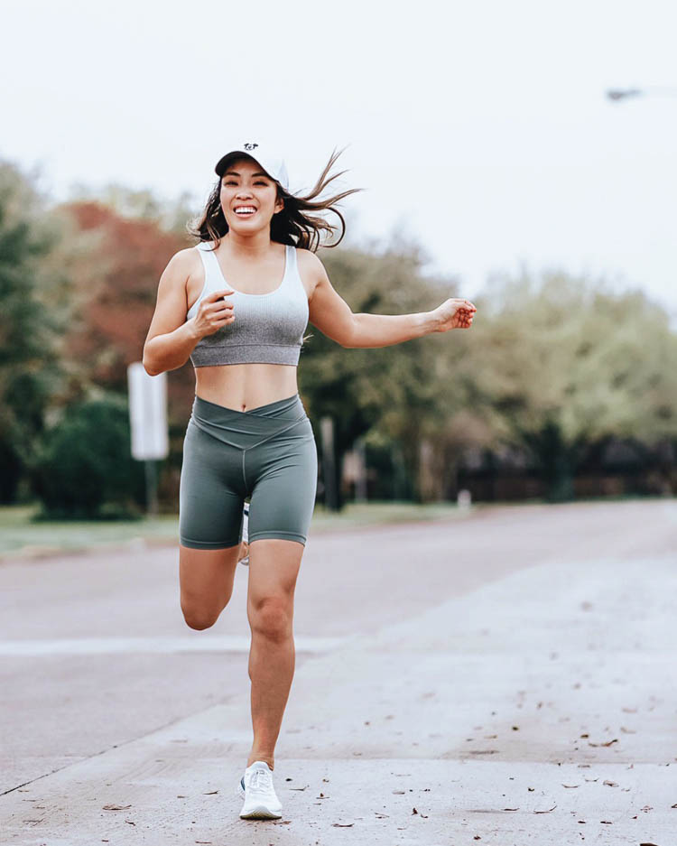 cute & little | dallas fitness lifestyle blogger | at home workouts | Best Online Home Workouts by popular Dallas lifestyle blog, Cute and Little: image of a woman running outside and wearing a Aerie Padded Bralette, Aerie REAL ME WRAP BIKE SHORT, Nike Epic React Flyknit, and a white Mickey Mouse ball cap. 