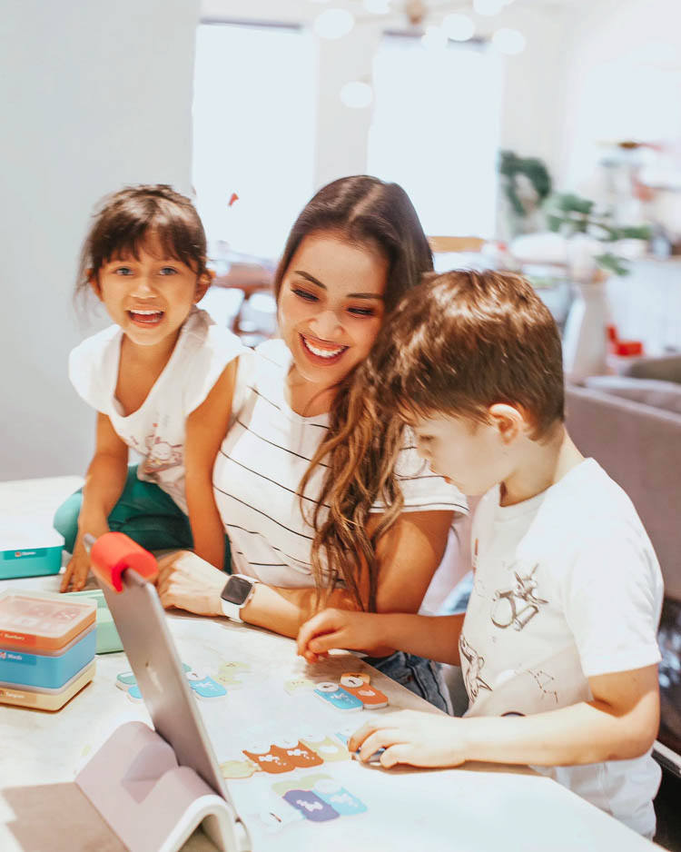 cute & little | stem education learning at home | osmo coding aubie review | Stem Games by popular Dallas lifestyle blog, Cute and Little: image of a mom and her kids using an Osmo kit. 
