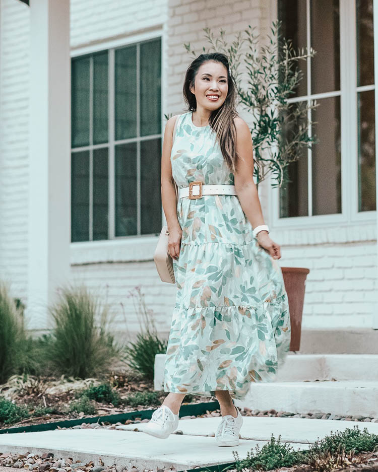 cute & little | dallas petite fashion blog | target spring dress april try-on haul | who what wear green floral dress | Target Summer Dresses by popular Dallas petite fashion blog, Cute and Little: image of a woman standing outside and wearing a Target A New Day Tiered Dress, Target Leather Woven Belt, Trask ‘Lindsey’ Sneakers, Amazon Pearl Clip Set, Fitbit ‘Versa’ Lite, and holding an Amazon clear tote bag. 