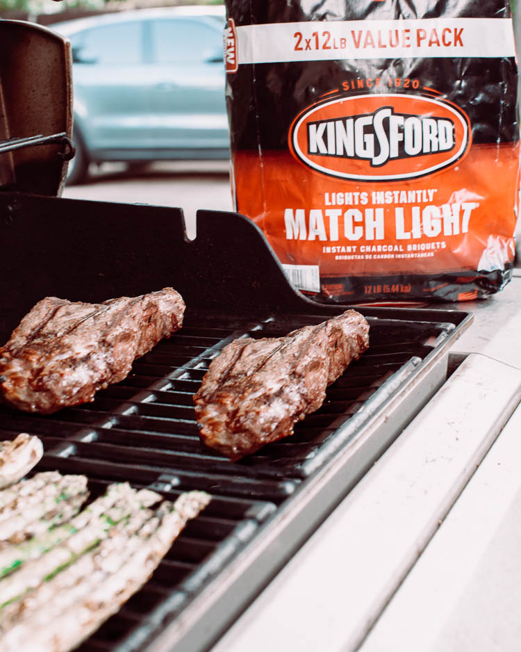 cute & little | dallas mom lifestyle blog | make awesome backyard summer memories | Kingsford Charcoal by popular Dallas lifestyle blog, Cute and Little: image of a man grilling meat and corn on the cob on a grill next to a bag of Kingsford Charcoal. 