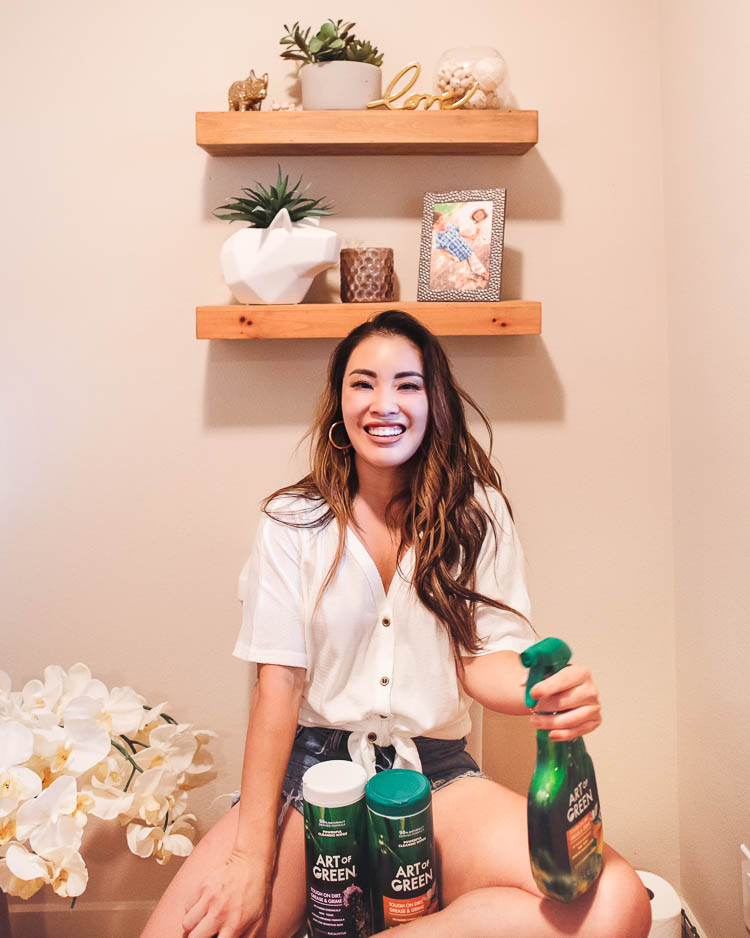 cute & little | dallas lifestyle mom blog | art of green eco-friendly cleaner review | 3 Easy Tips To Keep Your House Clean When You Have Kids | House Cleaning by popular Dallas lifestyle blog, Cute and Little: image of a woman sitting in her bathroom and holding various Art of Green cleaning products. 