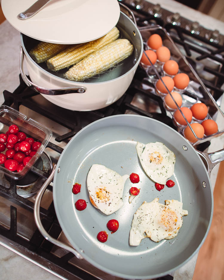 cute & little | dallas lifestyle mom blog | caraway home ceramic cookware set review | Caraway Cookware by popular Dallas lifestyle blog, Cute and Little: image of eggs, cherry tomatoes, and corn on the cob being cooked in some Caraway cookware. 