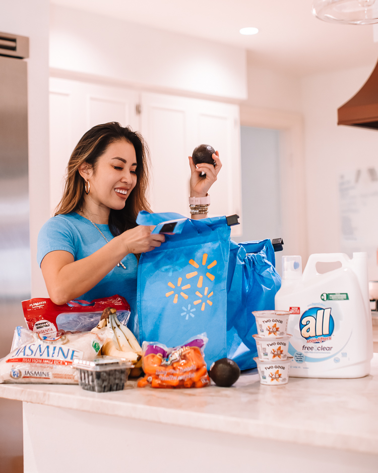 cute & little | dallas mom lifestyle blog | walmart express delivery review | Express Delivery Service by popular Dallas lifestyle blog, Cute and Little: image of a woman standing in her kitchen and unloading groceries from a reusable Walmart shopping bag. 