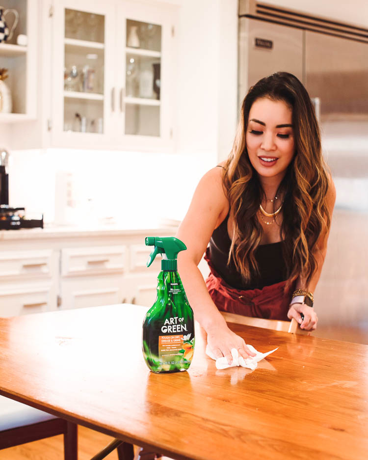 cute & little | dallas lifestyle mom blog | art of green eco-friendly cleaner review | 3 Easy Tips To Keep Your House Clean When You Have Kids | House Cleaning by popular Dallas lifestyle blog, Cute and Little: image of a woman using Art of Green cleaning product on her table top. 