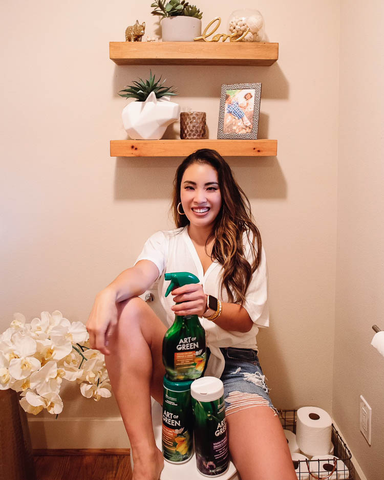 cute & little | dallas lifestyle mom blog | art of green eco-friendly cleaner review | 3 Easy Tips To Keep Your House Clean When You Have Kids | House Cleaning by popular Dallas lifestyle blog, Cute and Little: image of a woman sitting in her bathroom with various Art of Green cleaning products. 
