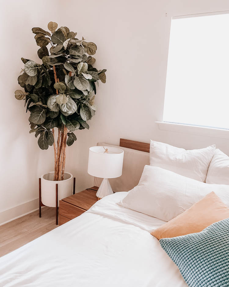 cute & little | dallas lifestyle blog | mid century modern master bedroom home faux greenery fiddle leaf fig decor | Mid Century Modern Bedroom by popular Dallas life and style blog, Cute and Little: image of a master bedroom decorated with a Overstock fiddle leaf fig tree, Allmodern Gramercie Ceramic Pot Planter, West Elm Metalized Glass USB Table Lamp.