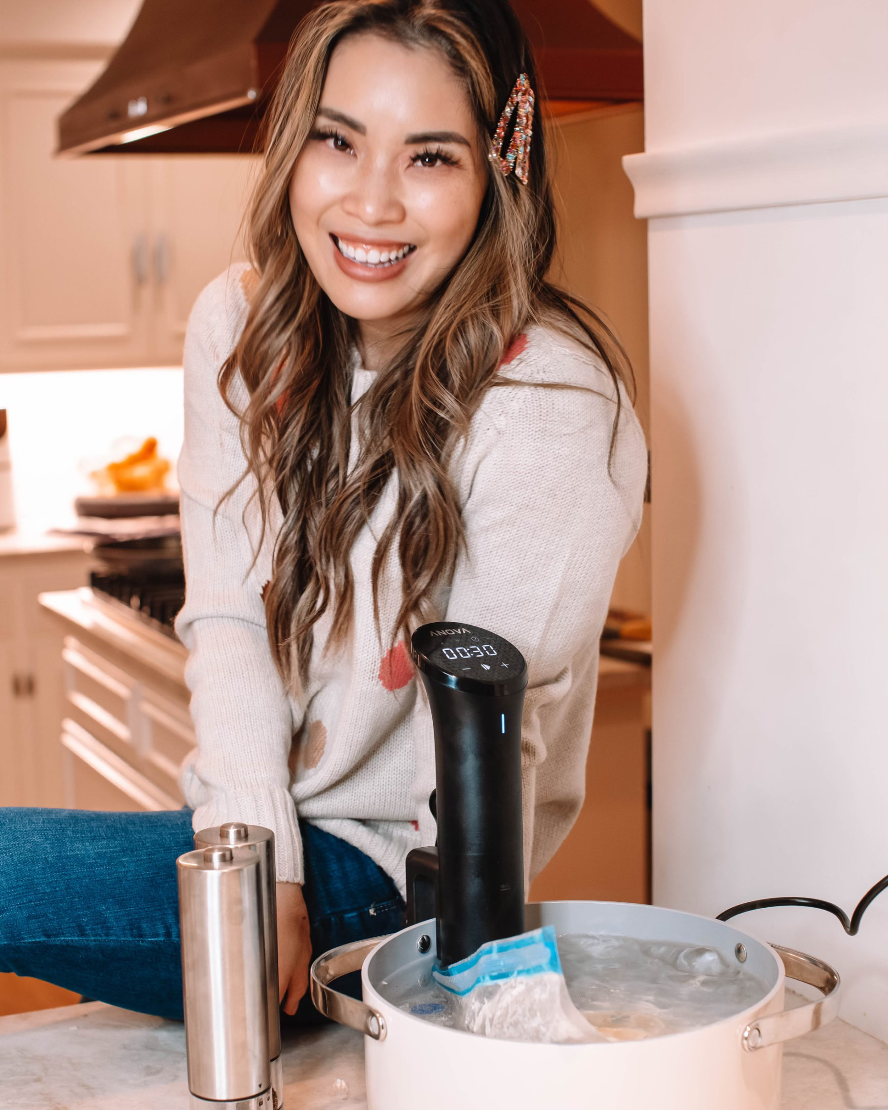 cute & little | dallas fashion lifestyle blog | anova nova sous vide review cooking lemon garlic halibut recipe |What is Sous Vide by popular Dallas lifestyle blog, Cute and Little: image of a woman sitting next to a pot of water with a Anova Nova Sous Vide attached to it. 