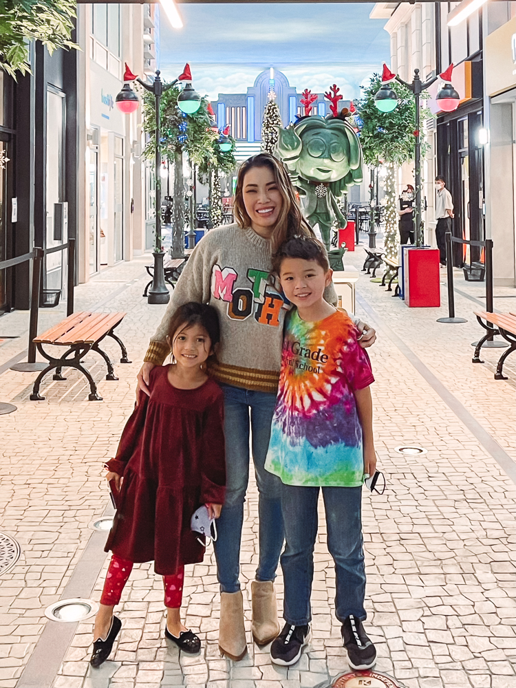 cute & little | dallas mom lifestyle blog | things to do frisco holidays 2020 | kidzania review |Things to do in Frisco TX by popular Dallas travel blog, Cute and Little: image of a mom and her two kids at Kidzania. 
