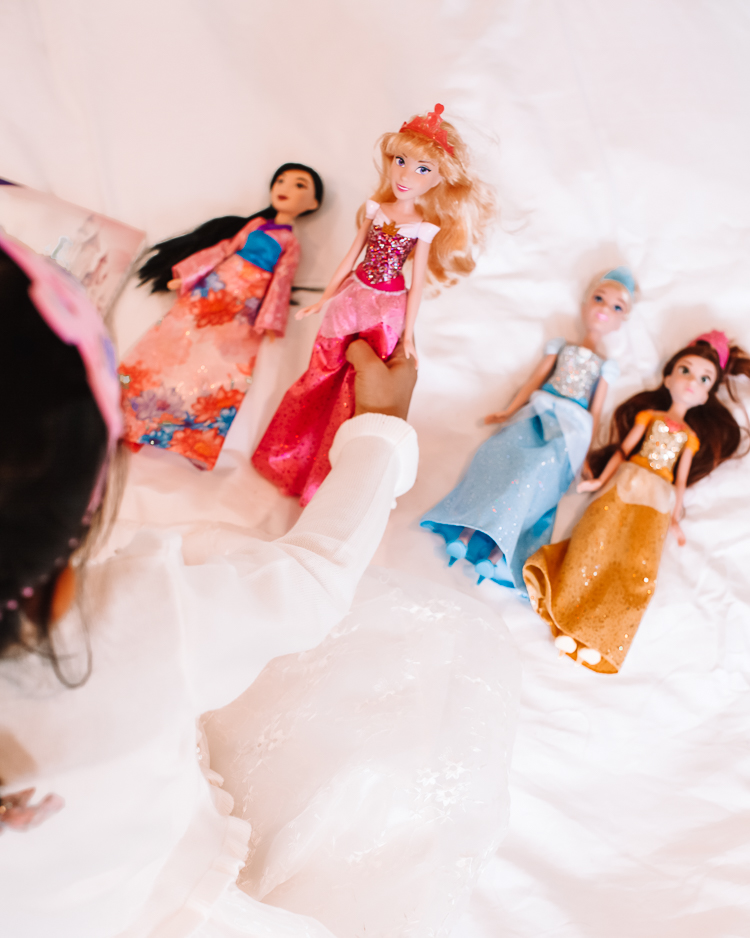 cute & little | dallas petite fashion blog | hasbro disney princess royal shimmer fashion doll unboxing review | girls holiday 2020 gift guide idea |Disney Princess Dolls by popular Dallas lifestyle blog, Cute and Little: image of a little girl holding Disney princess dolls in her hands. 