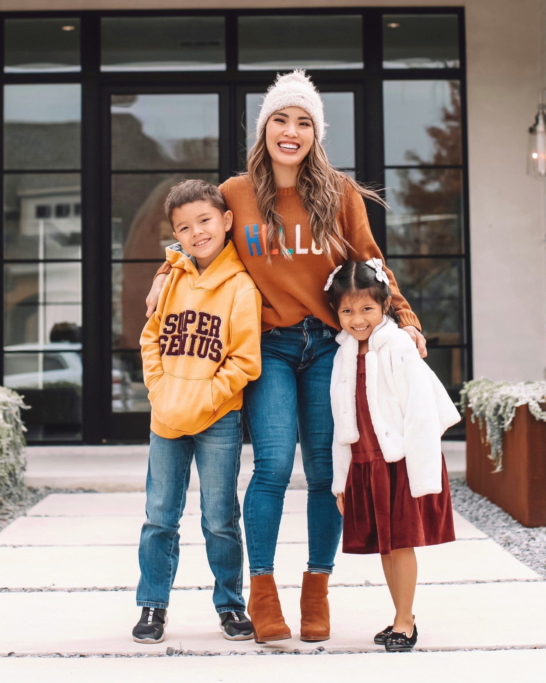 cute & little | dallas petite fashion blog | how to create a home you love | life tips | Create a Home by popular Dallas life and style blog, Cute and Little: image of a mom standing outside with her son and daughter and wearing a Hello Sweater, brown suede ankle boots, jeans, Super Genius hoodie, cream pom beanie, Nike shoes, Tucker + Tate jeans, Velour dress, cat ballet flats, and white floral print hair bows. 