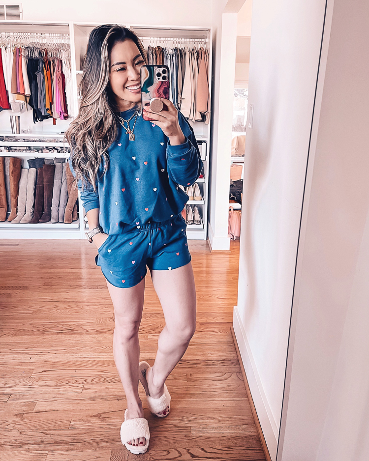 cute & little | dallas petite fashion blog | target loungewear try-on | blue heart sweatshirt shorts pajama set |Target Loungewear by popular Dallas petite fashion blog, Cute and Little: image of a woman wearing a Target heart dot pajama set with a pair of fuzzy slippers. 