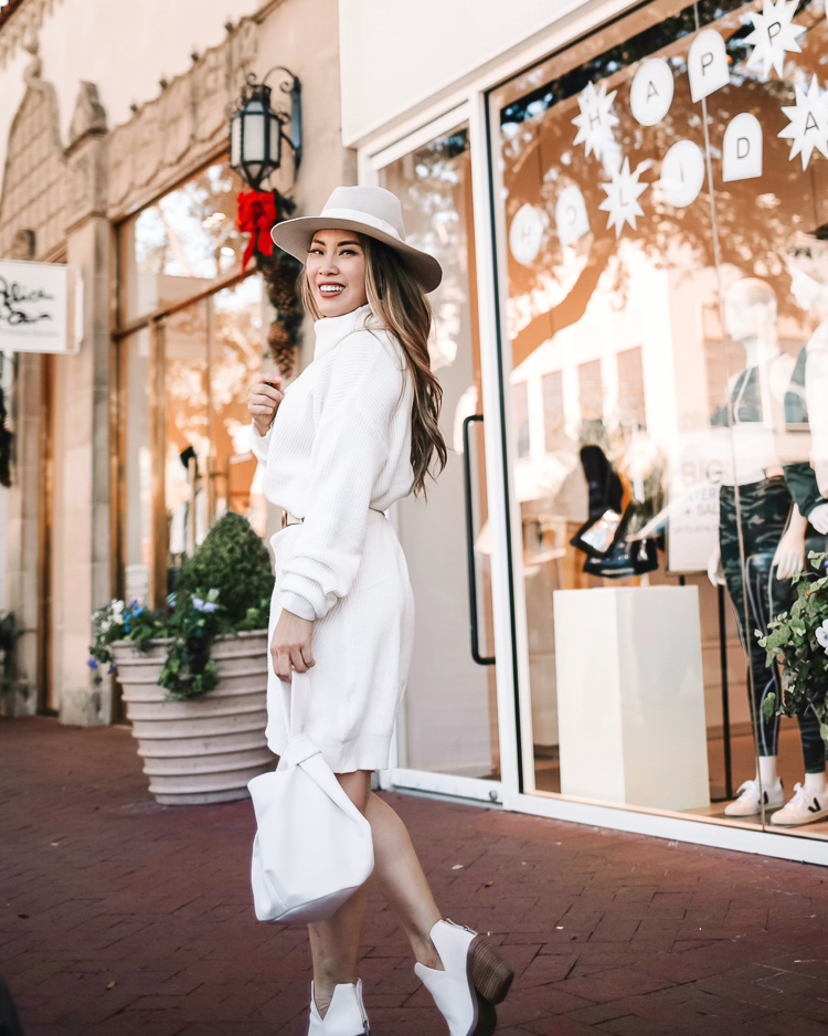 cute & little | dallas petite fashion blog | amazon winter white knit sweater dress how to style |How to Style a Sweater Dress by popular Dallas petite fashion blog, Cute and Little: image of a woman wearing a white Amazon cable knit sweater dress, white Gucci belt, white ankle boots, grey felt fedora hat and holding a white bag. 