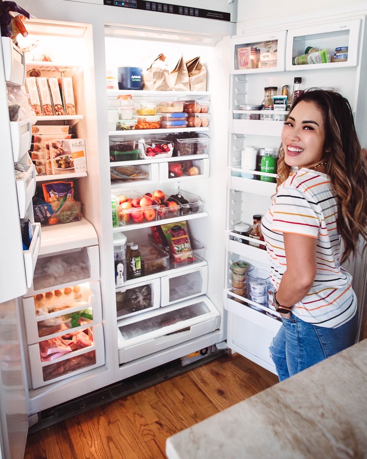 cute & little | dallas mom lifestyle blog | fridge organization tips and must-haves from walmart |Walmart Fridge Organization by popular Dallas lifestyle blog, Cute and Little: image of a woman standing in front of her open fridge. 