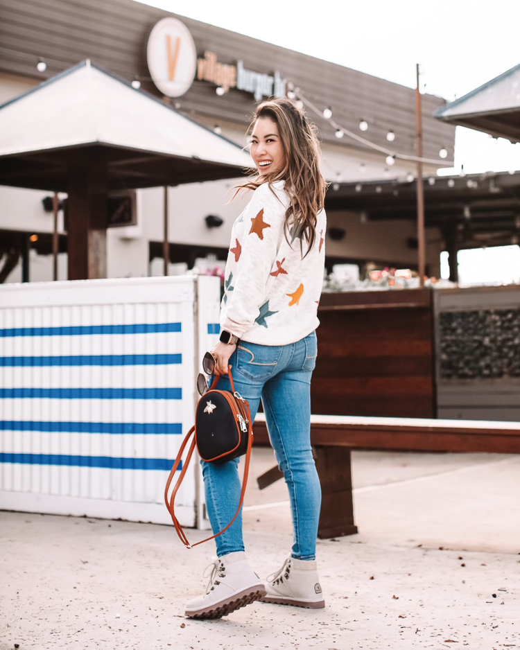 cute & little | dallas petite fashion blog | loft lou grey star sweater | spring transition outfit |Lightweight Sweaters by popular Dallas petite fashion blog, Cute and Little; image of a woman wearing a Loft Lou & Grey star print sweater, jeans, and white combat boots. 