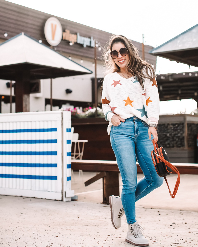5 Lightweight Sweaters To Transition Into Spring |Lightweight Sweaters by popular Dallas petite fashion blog, Cute and Little; image of a woman wearing a Loft Lou & Grey star print sweater, jeans, and white combat boots. 
