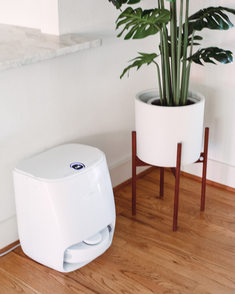 cute & little | dallas mom blog | narwal self-cleaning robot mop vacuum review |Narwal Robot Vacuum by poplar Dallas lifestyle blog, Cute and Little: image of a Narwal robot vacuum next to a white ceramic planter containing a house plant. 