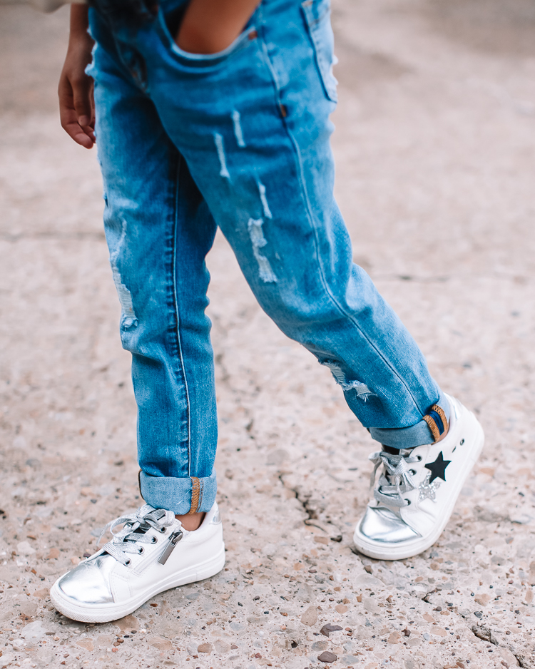 cute & little | dallas mom family blog | kidpik review | best kids style box |KidPik Box by popular Dallas petite fashion blog, Cute and Little: image of a young girl standing outside and wearing a pair of distressed jeans and silver sneakers.