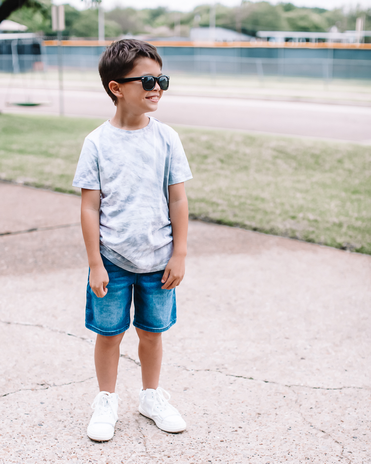 cute & little | dallas mom family blog | kidpik review | best kids style box |KidPik Box by popular Dallas petite fashion blog, Cute and Little: image of a young boy standing outside and wearing a grey tie dye shirt, jean shorts, white sneakers, and black sunglasses. 