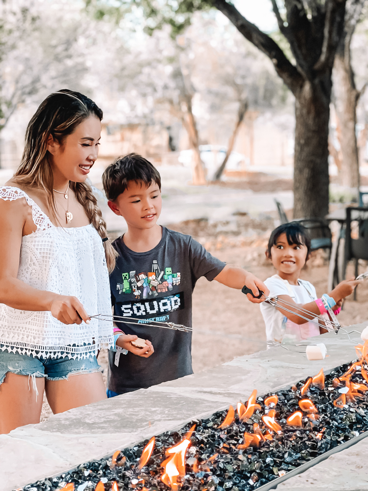 cute & little | dallas mom family travel blog | schlitterbahn new braunfels review tips | schlitterstein lofts smores | Schlitterbahn Waterpark by popular Dallas travel blog, Cute and Little: image of mom and her son and daughter roasting marshmallows at Schlitterbahn Waterpark. 