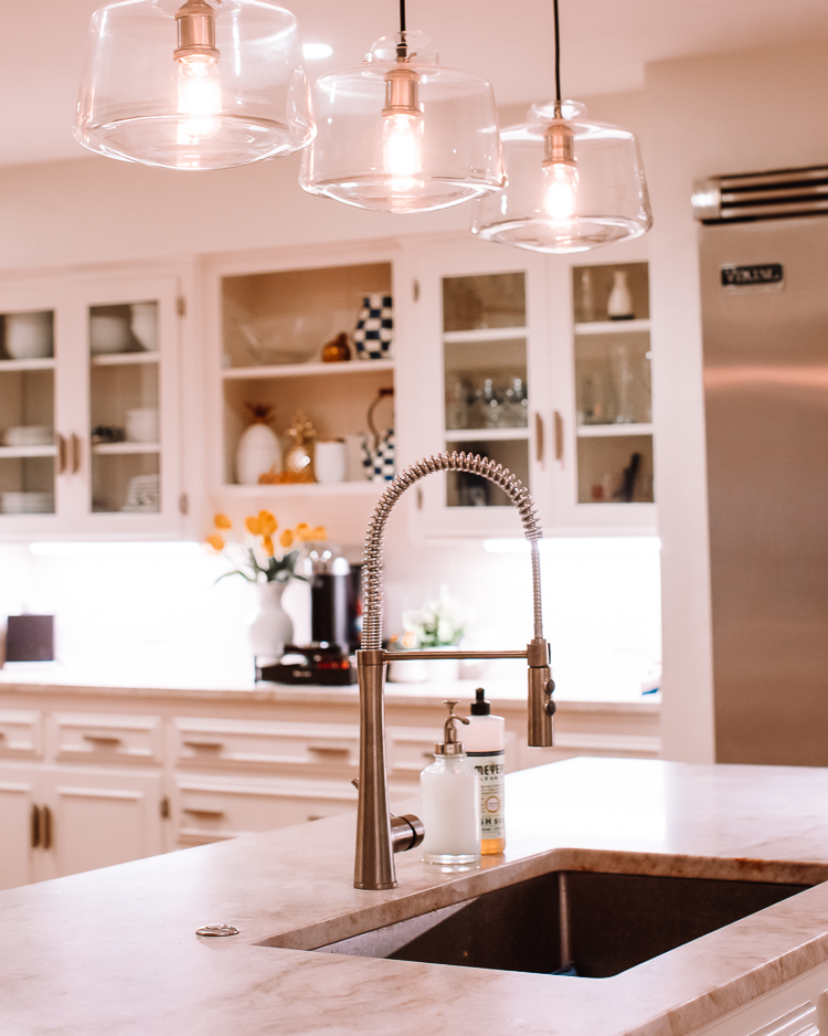cute & little | dallas home blogger | white kitchen remodel mid-century modern | Mid Century Modern Kitchen by popular Dallas life and style blog, Cute and Little: image of a kitchen with white cabinets, silver appliances, white backsplash, gas stovetop and light wood floors. 