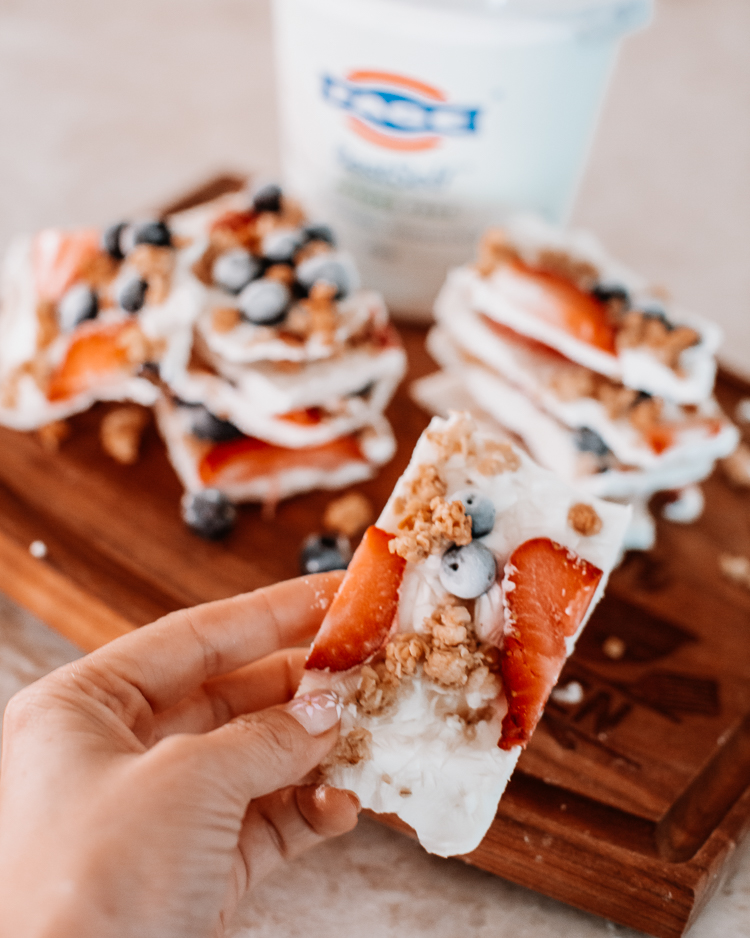 cute & little | dallas mom blog | summertime healthy snack | yogurt bark with berries | Yogurt Bark With Berries by popular Dallas lifestyle blog, Cute and Little: image of a woman holding some yogurt bark with berries. 